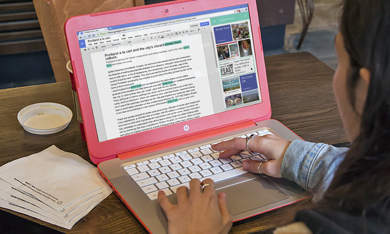 A person is editing a text document with images inside a cafe